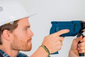 Hombre con un taladro haciendo un agujero en un muro de carga