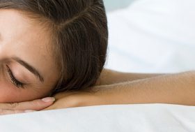 Mujer durmiendo boca abajo sobre una almohada