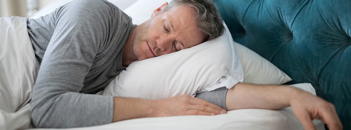 Hombre durmiendo boca abajo sobre una almohada