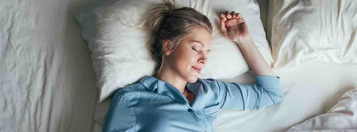 Mujer durmiendo boca arriba sobre una almohada