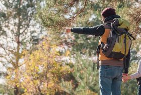 Padre e hijo con una mochila puesta en el campo