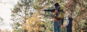 Padre e hijo con una mochila puesta en el campo